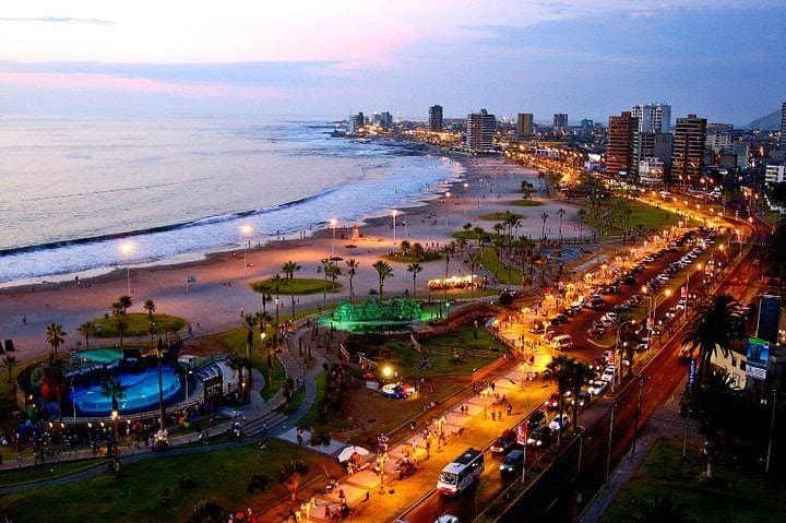 Costanera de Santiago iluminada al atardecer con el mar y la avenida